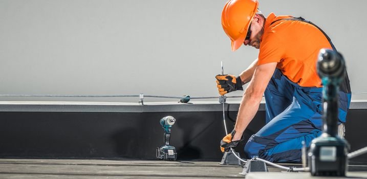 Técnico revisando y dando mantenimiento a una instalación de pararrayos